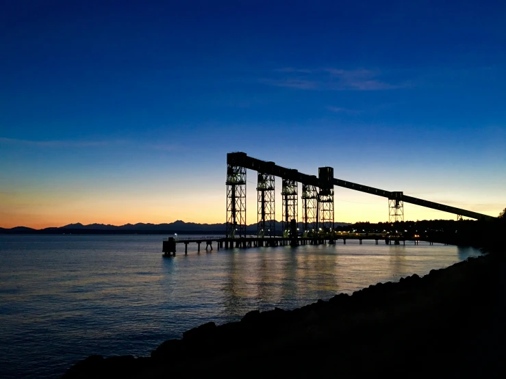 an industrial dock is seen at dusk over the water