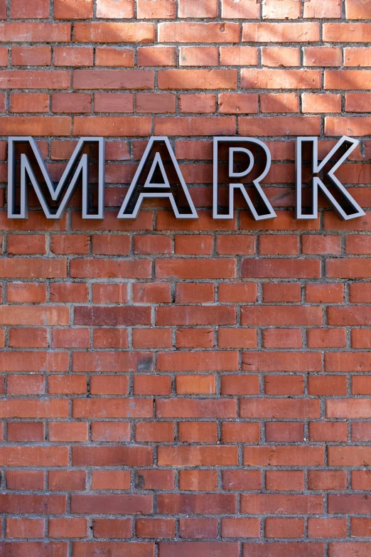 a brick building with a large, large, metal word that says mark on it