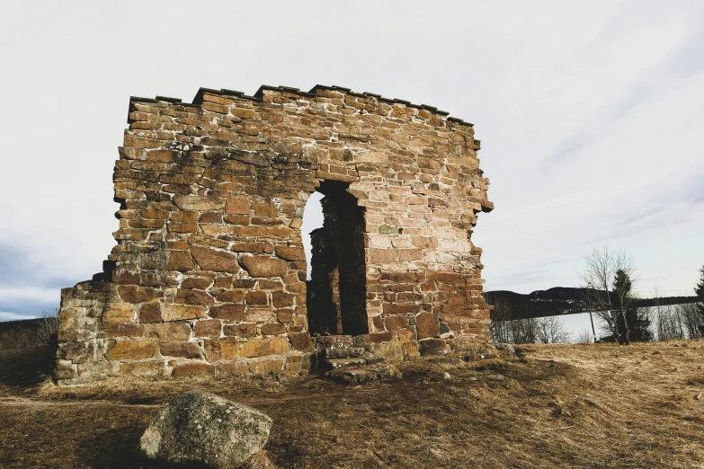 an old stone building sits on a hill