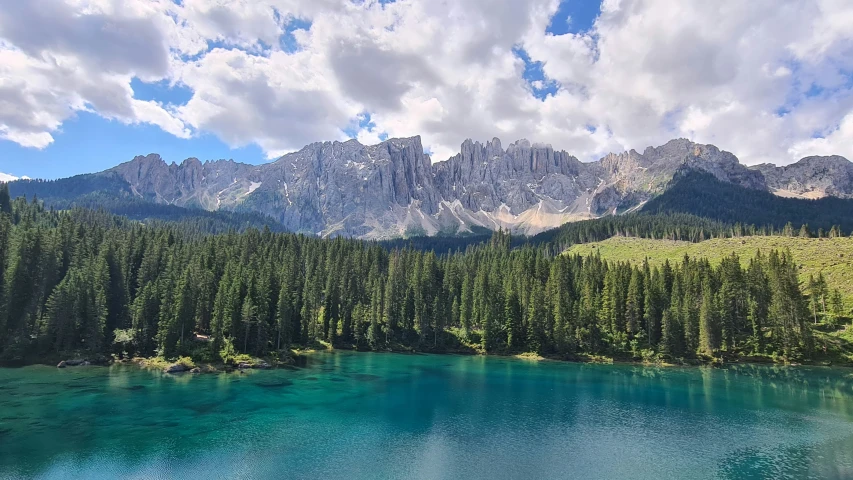 a small lake sits in the mountains with blue water