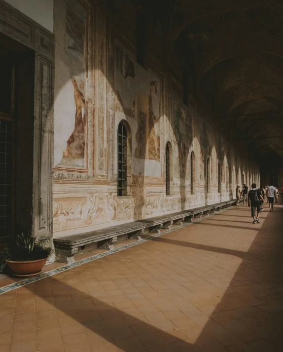 a long corridor with arches and people walking around