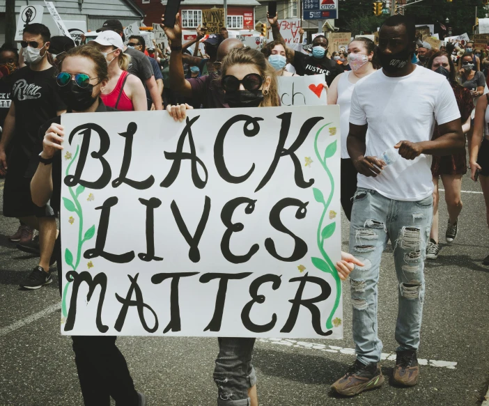 a protester holds up a sign in front of others