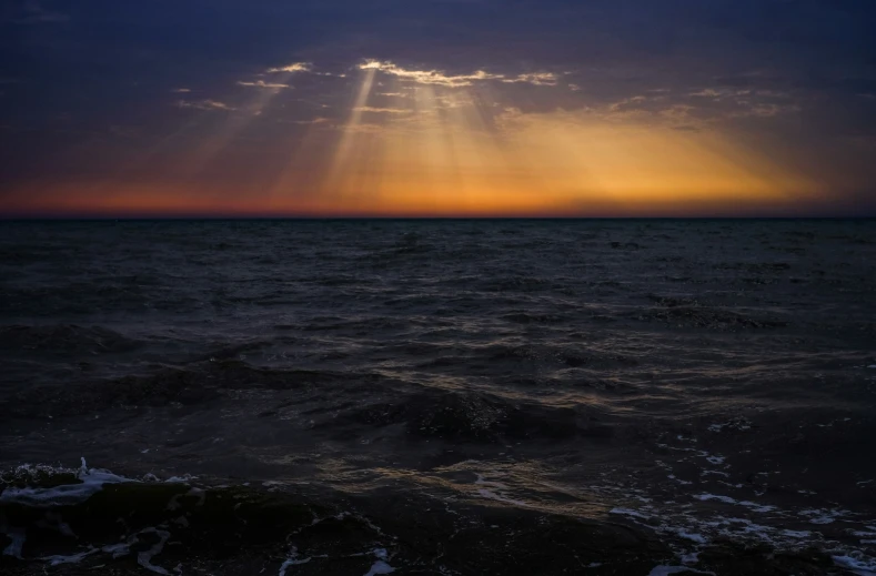 a boat is heading into a beautiful sunset in the ocean