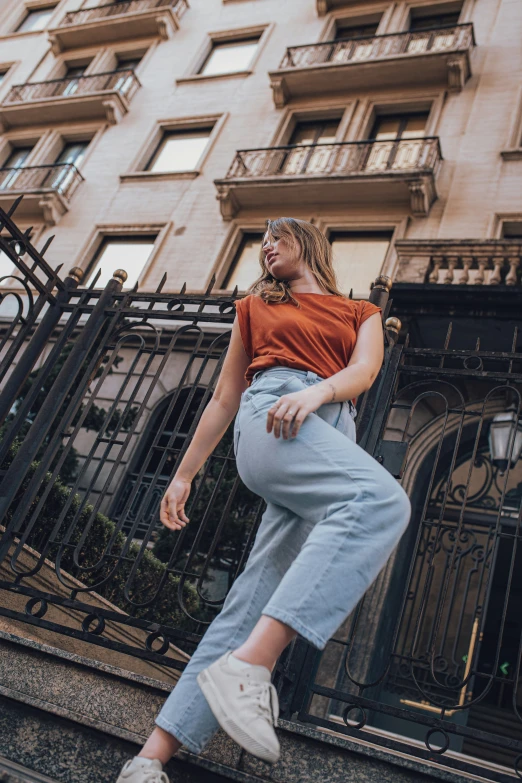 a woman is walking by a wrought iron fence