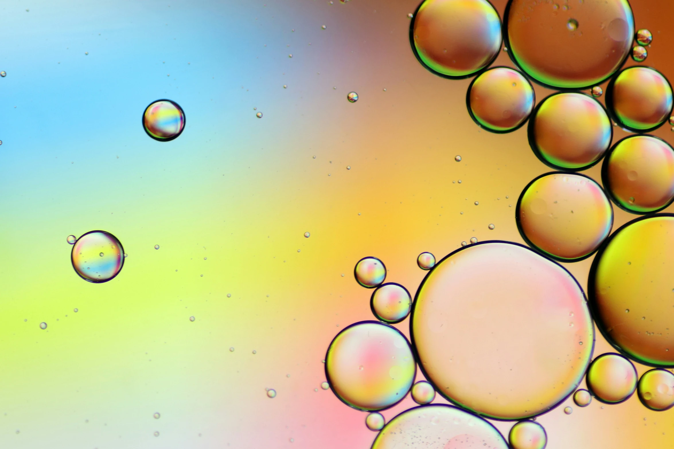 a background with bubbles floating in a blue, green, yellow and pink liquid