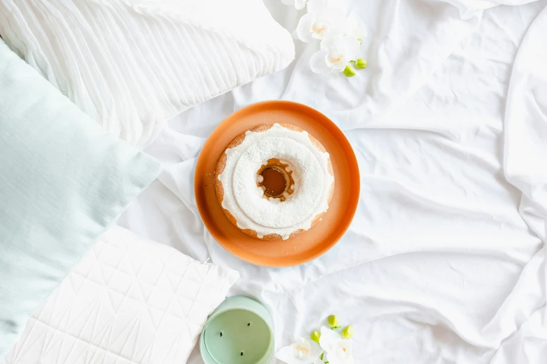 cake on a red plate, coffee and flowers on the bed