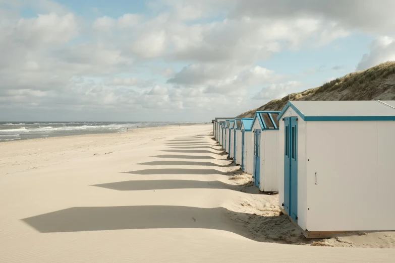 there are a bunch of white beach huts on the beach