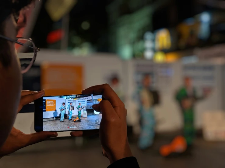 a person holds up their cell phone to take a picture of people in scrubs