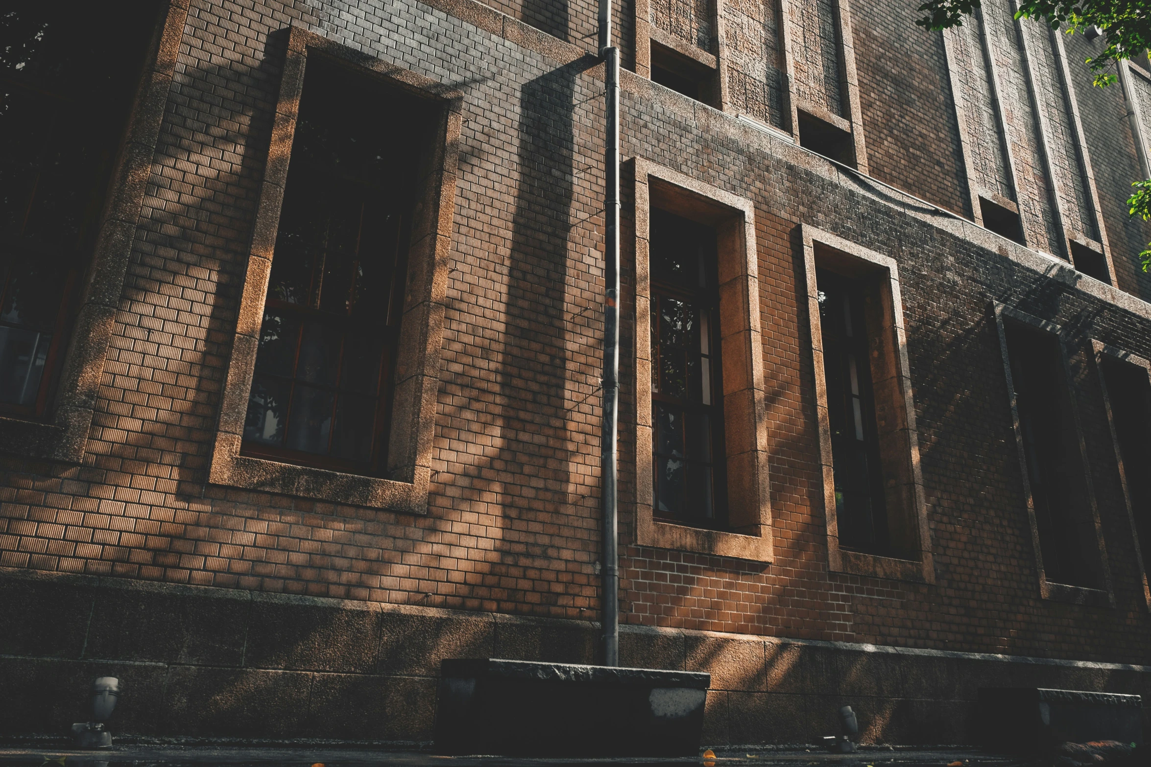 a tall brick building has two windows in it