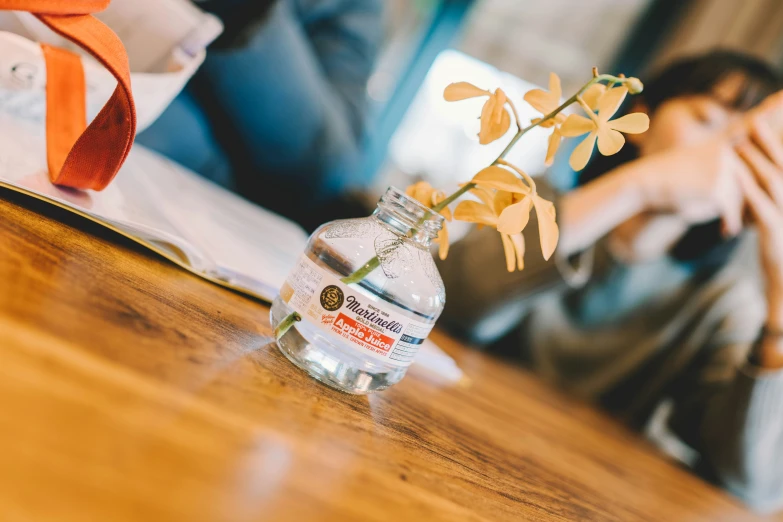 small vase with flowers in front of a lady's laptop