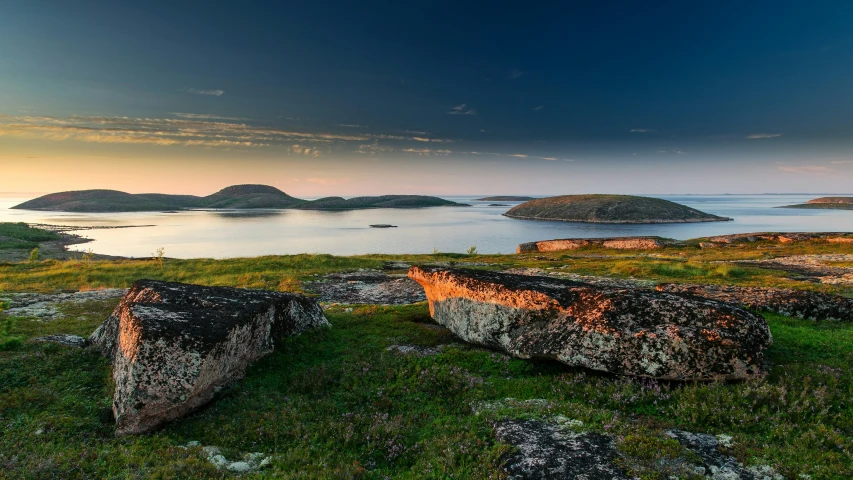 an island covered in green grass near a body of water