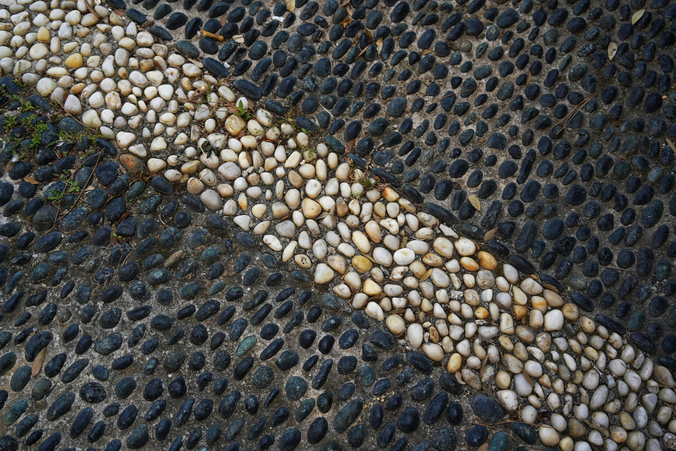 a road with pebbles and a curb line