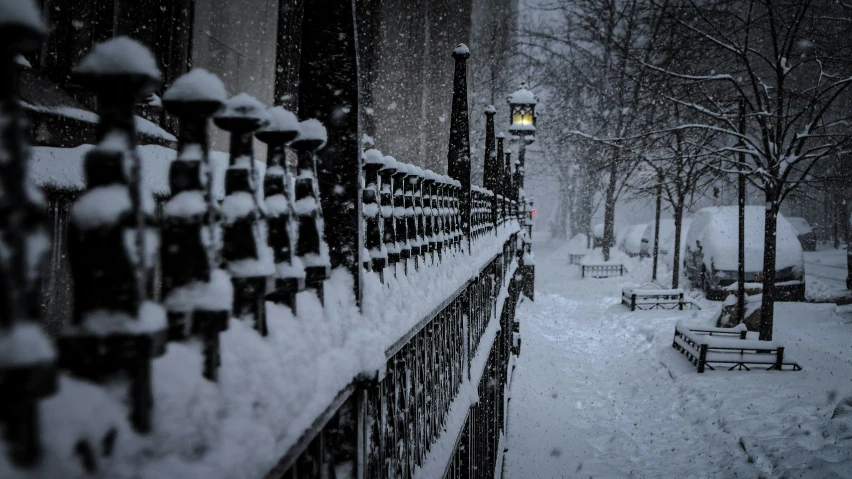 a snow covered park next to trees and buildings