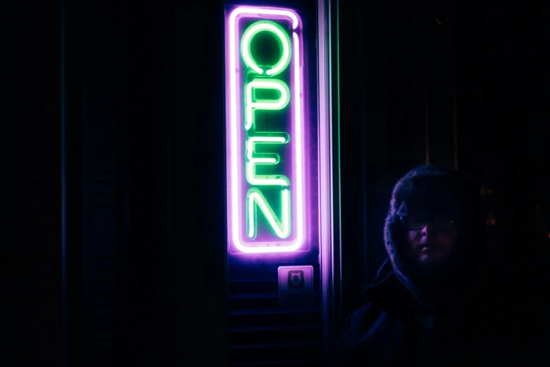 a man in front of a neon sign