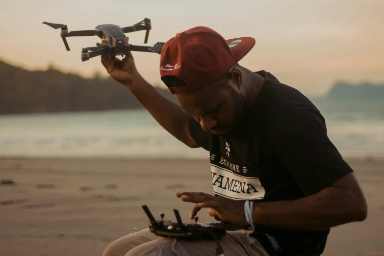 a man with a camera and a remote controlled hovering above his head