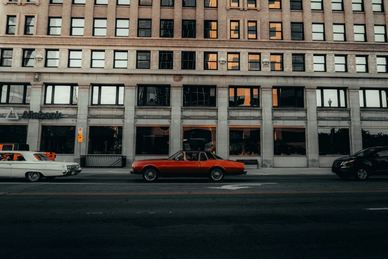 cars are parked on the road near tall buildings