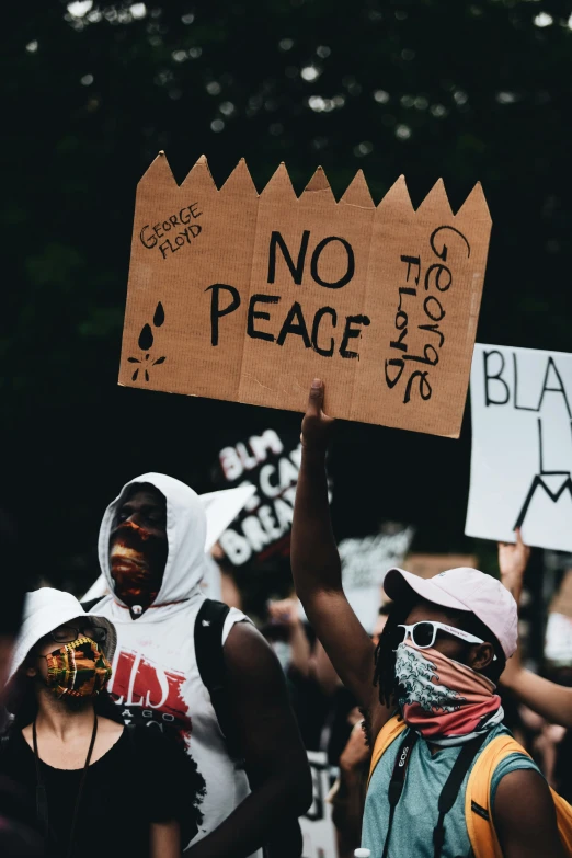 two people holding signs, one of them with no peace written on them