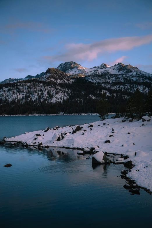 snow covered rocks and rocks near water