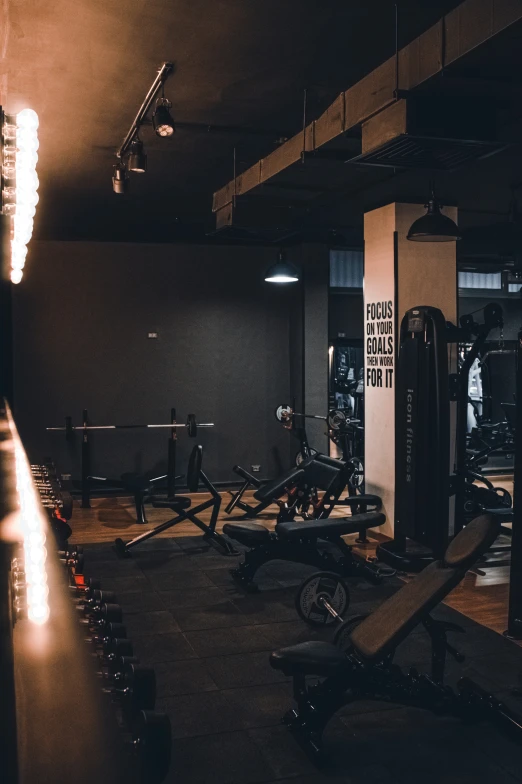 a dimly lit gym with a row of exercise machines