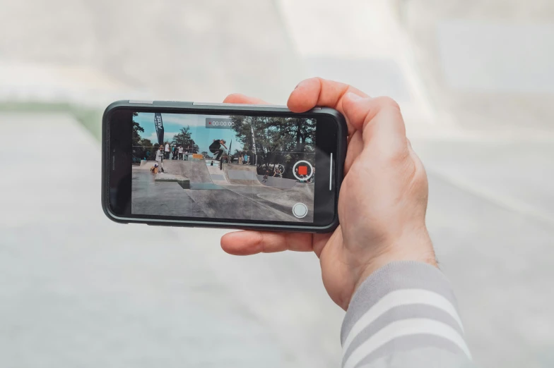 a person taking a picture of a skateboarder in a street