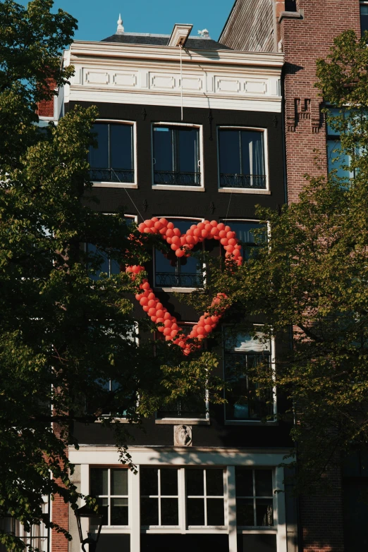 a balloon heart that is hanging on the side of a building