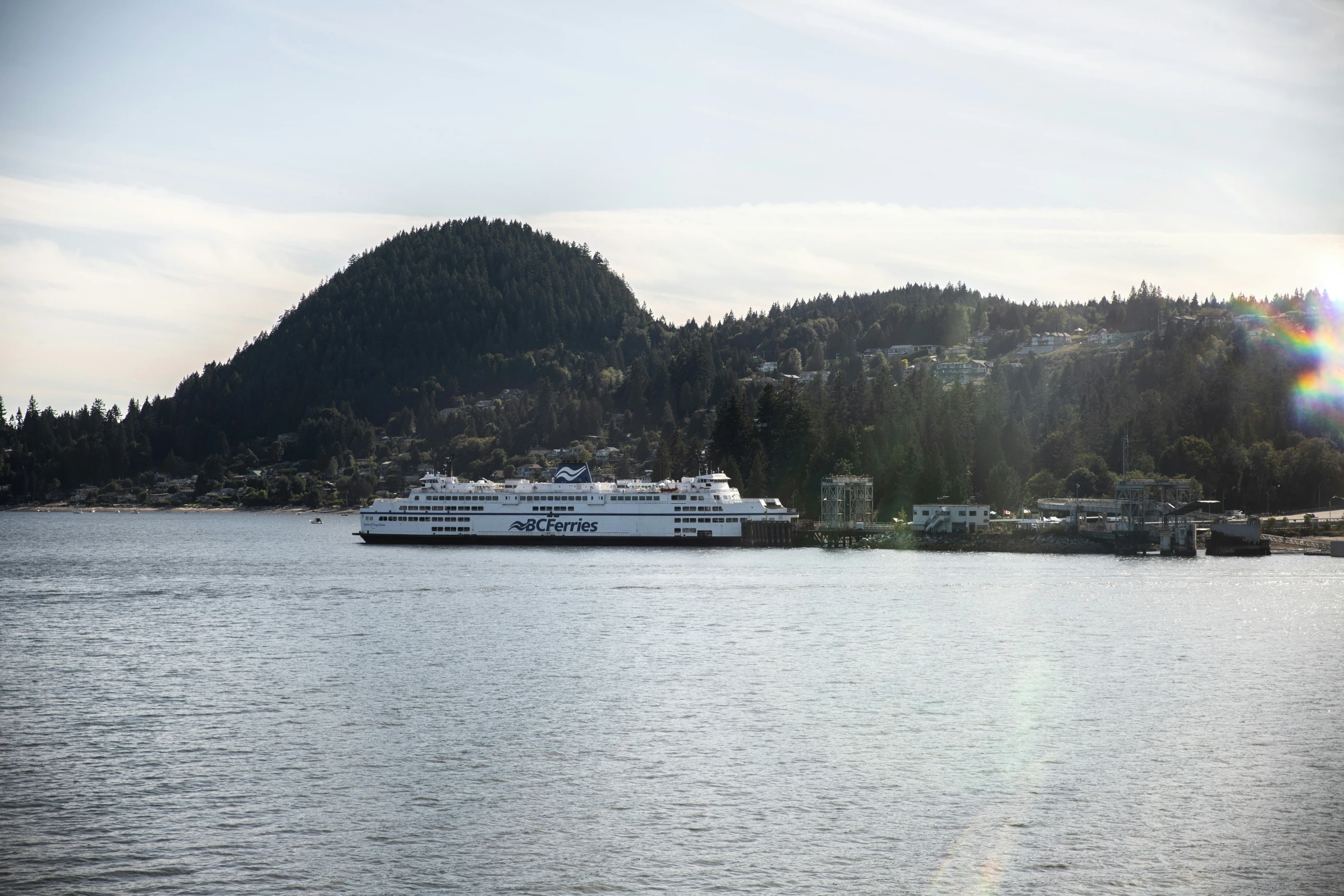 the ferry is anchored at the pier by the mountain