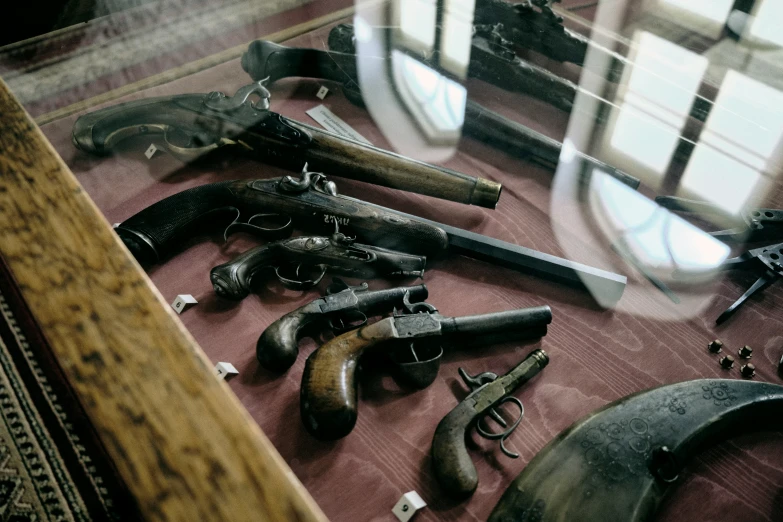 a collection of old guns that are being displayed