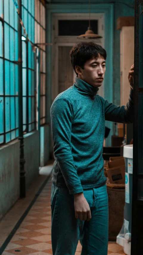 a young man is leaning on a door