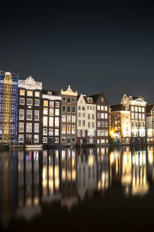 some buildings are by the water and buildings at night