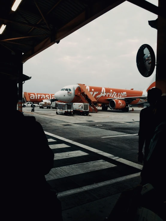 an orange and white plane sitting on the tarmac