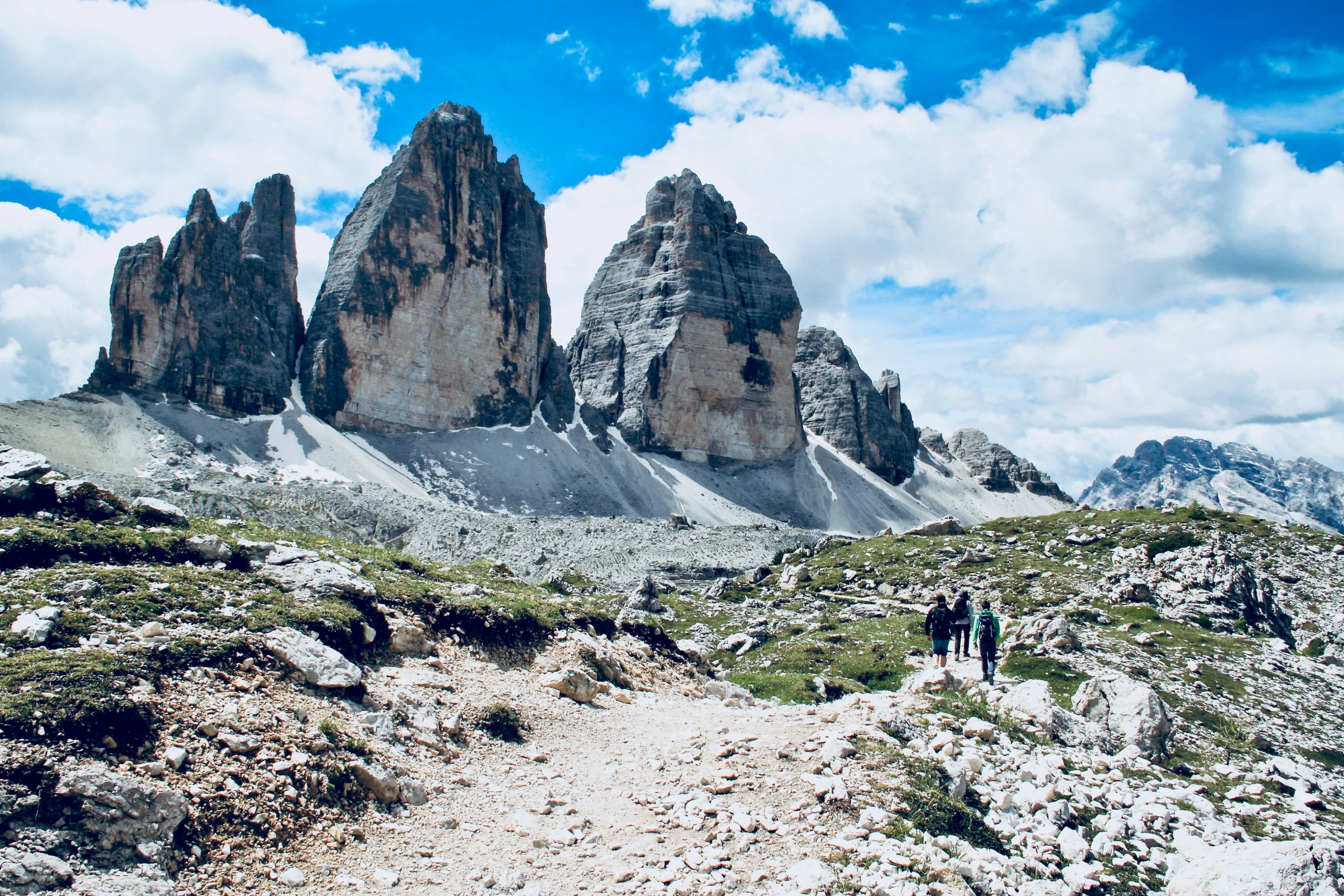 a couple standing on a mountain trail with some big rocks