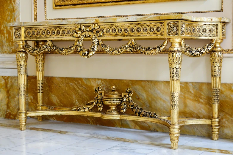 a large golden console table with golden trim