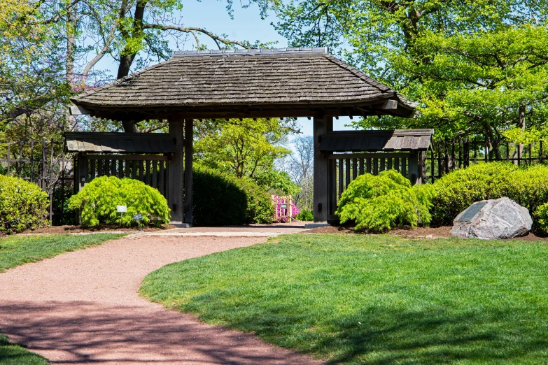 an old - fashioned garden gazebo surrounded by lush green trees