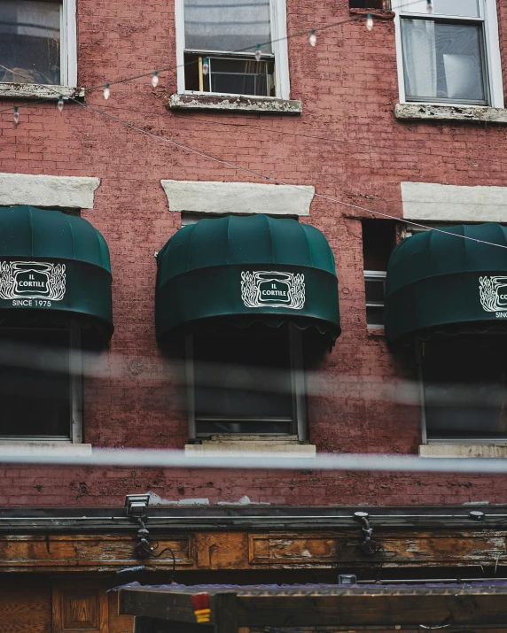 a red brick building with green awnings