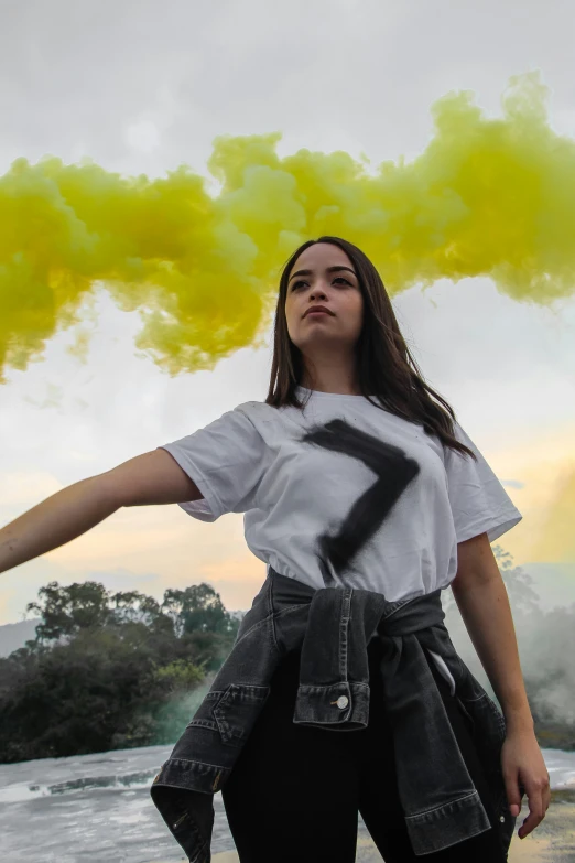 a woman is holding a black marker in her hands as smoke shoots from the sky