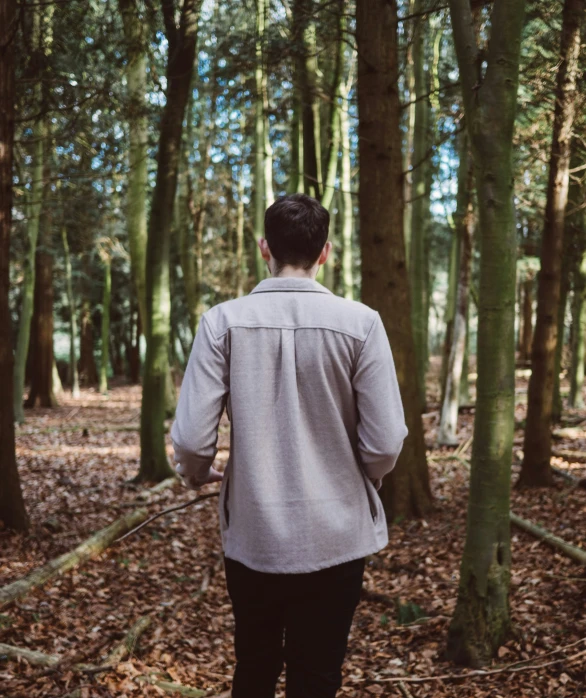 the person is walking through the woods with many trees