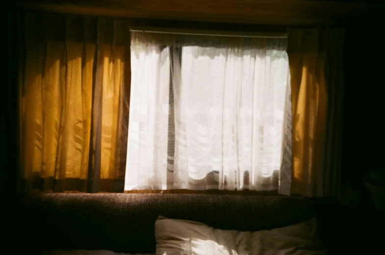 the window that the curtains are open by the bed