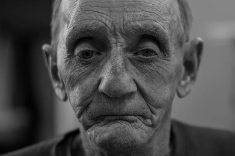 an elderly man looking into the distance with a puzzled expression