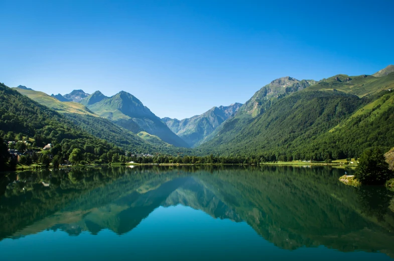 mountains surrounding a body of water surrounded by lush greenery