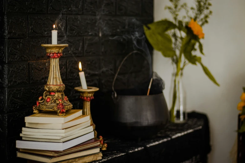 candles and books on an ornate fireplace mantle