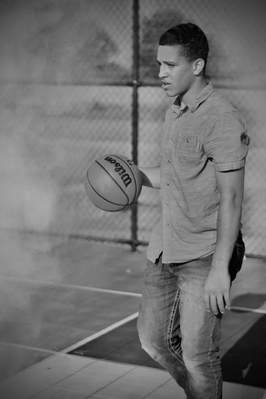 a black and white image of a man playing basketball