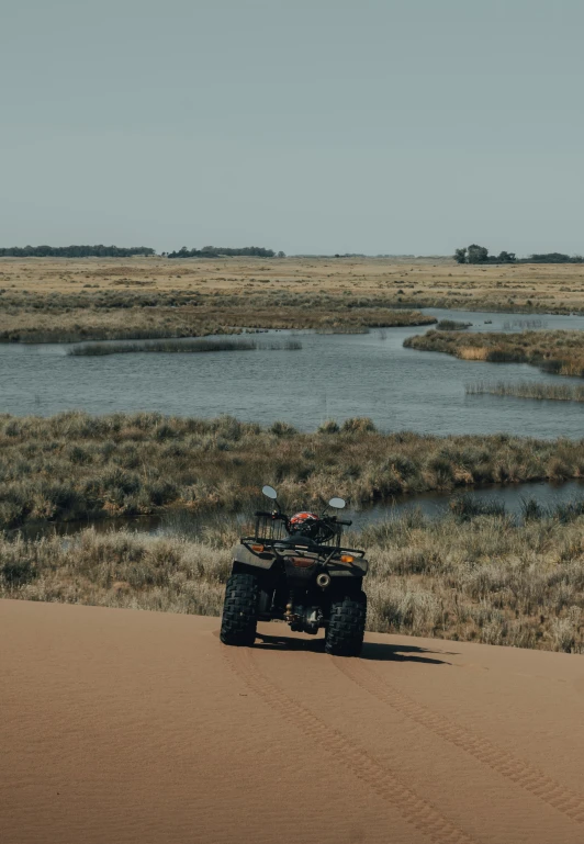 an atv riding across a dry grass field