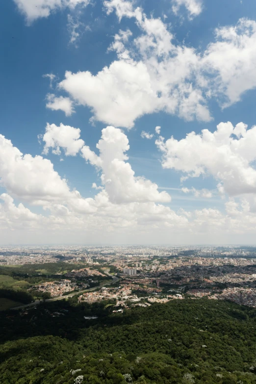 a city with lush green hills and blue skies