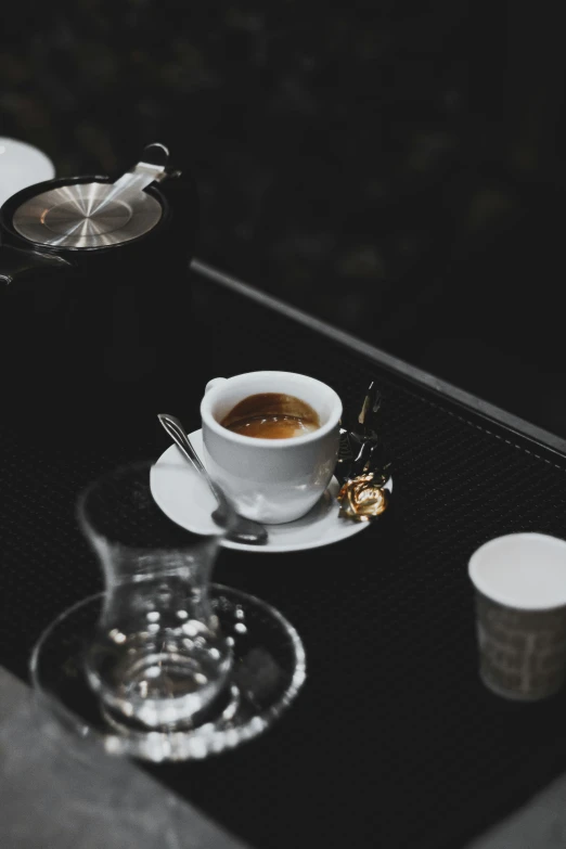 a table that has coffee, saucer and a spoon on it