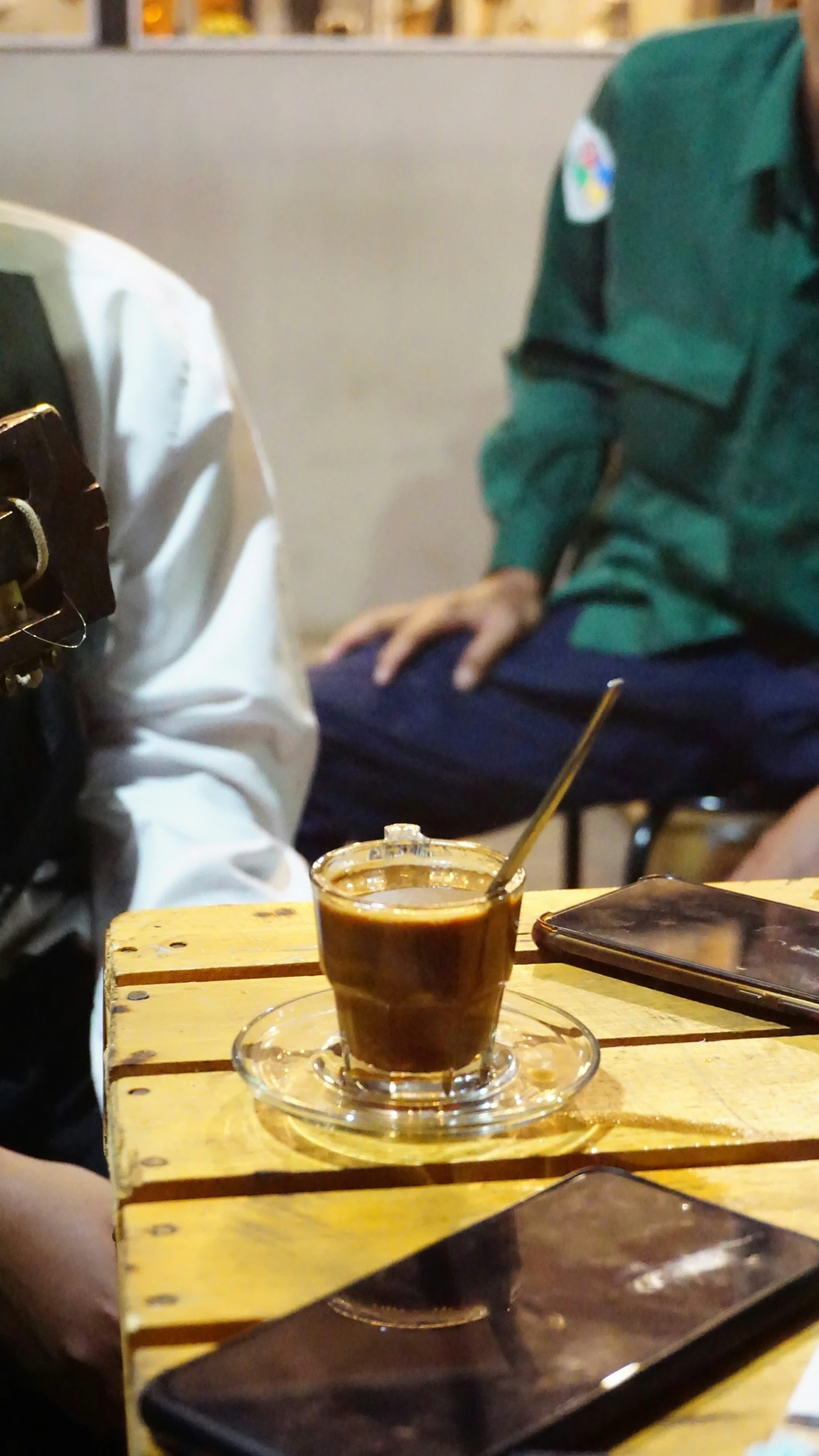 two people sit in a restaurant while two drinks sit on a table