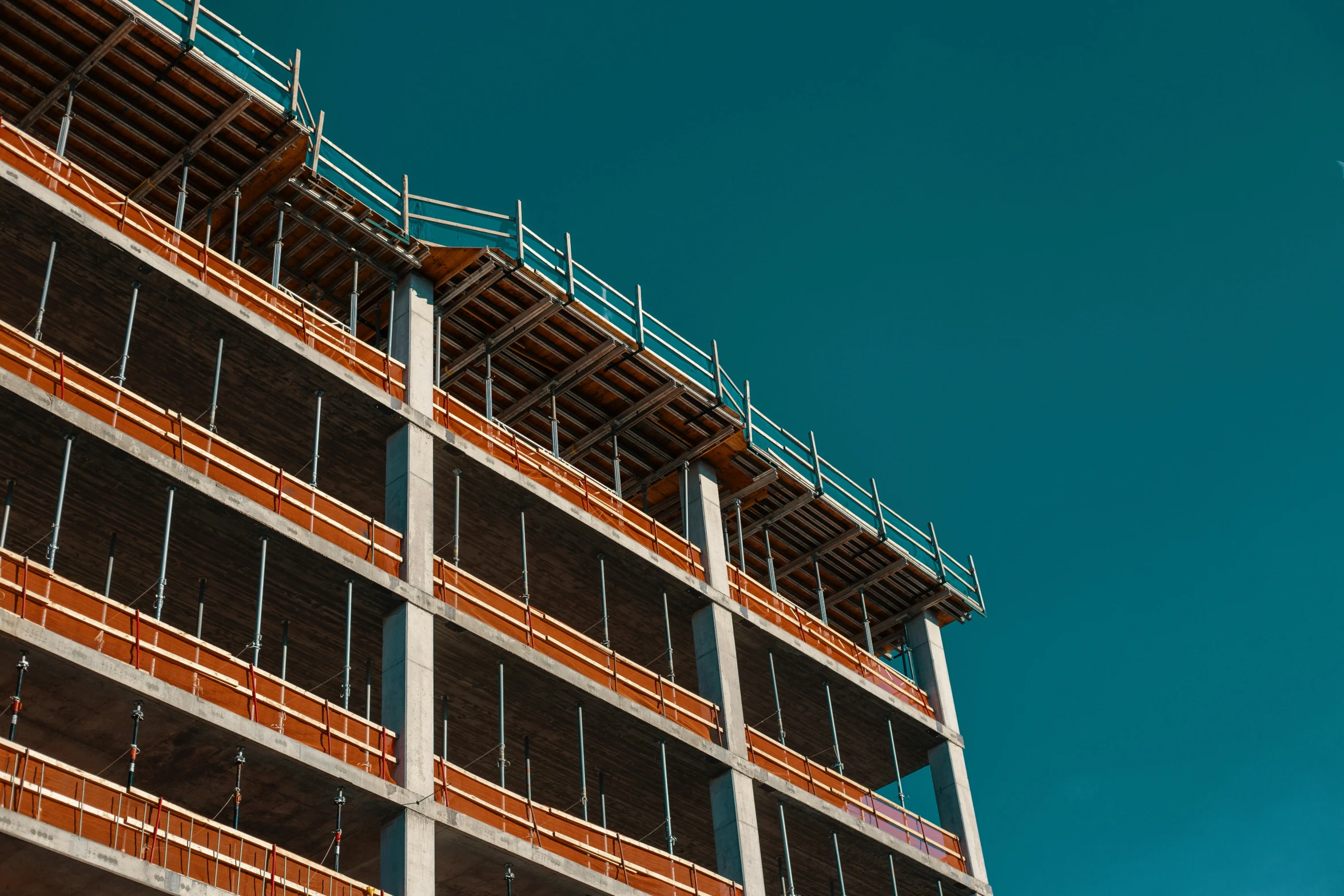 a building under construction with a plane flying high above