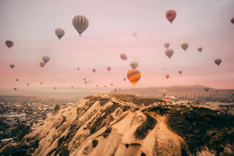 many  air balloons are flying over the mountain