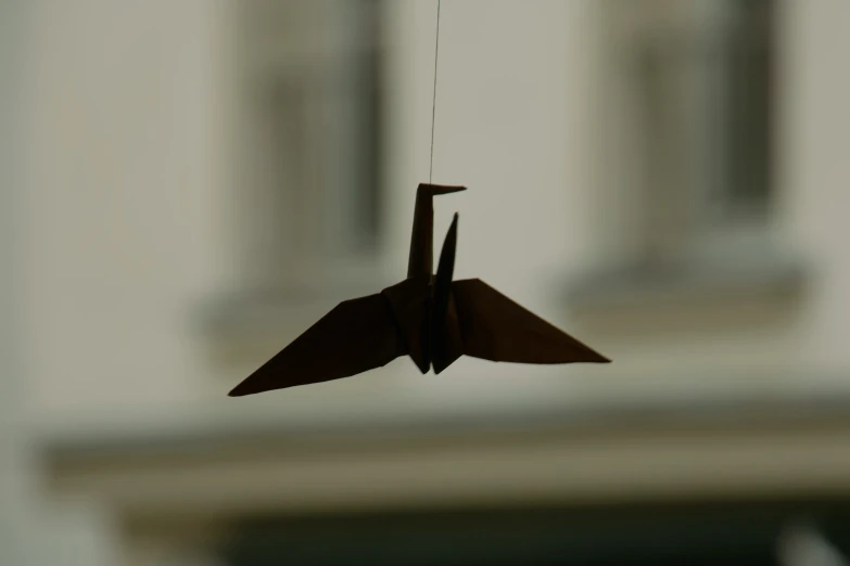 a paper crane hanging on a cord