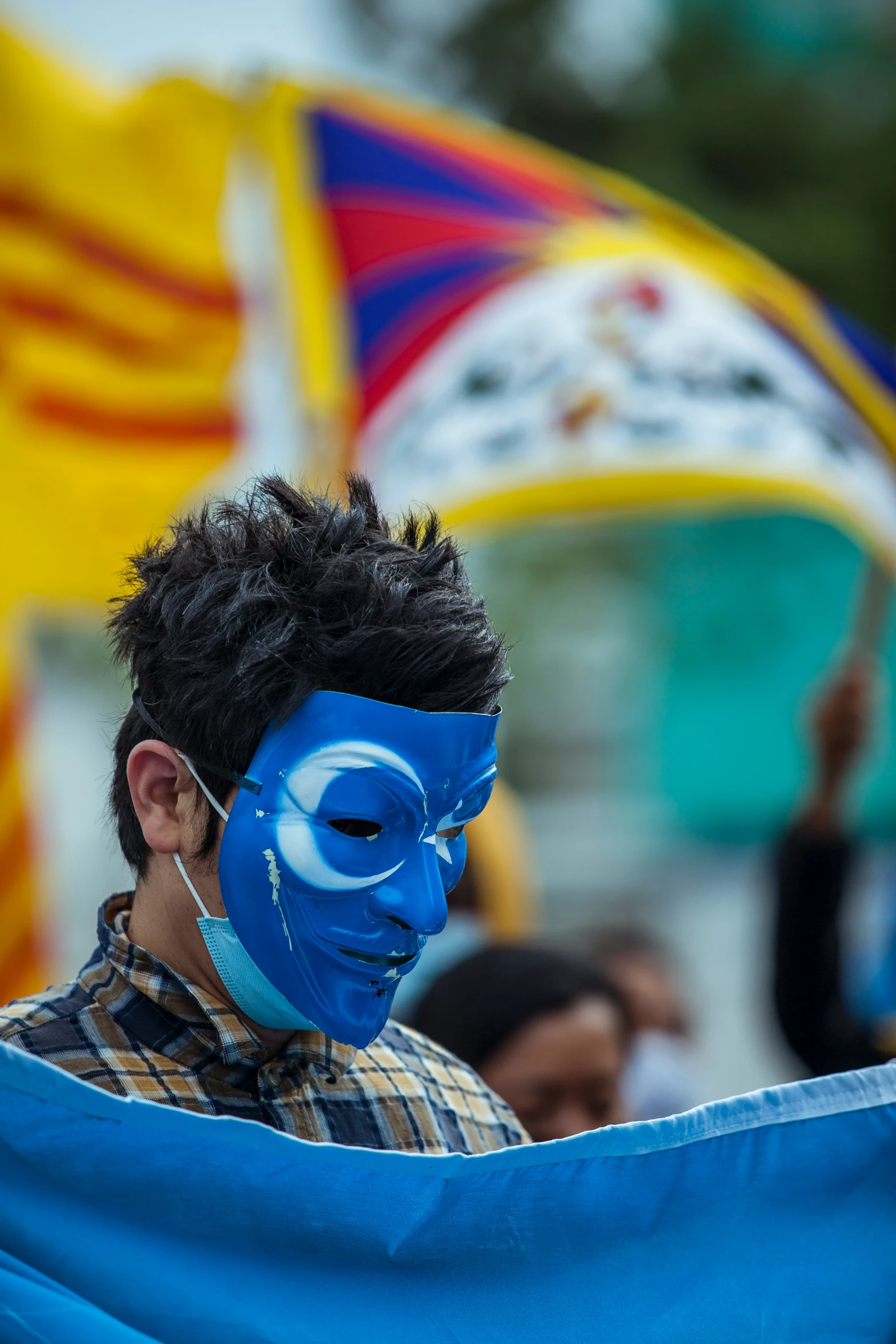 a boy with black hair and a blue face paint on