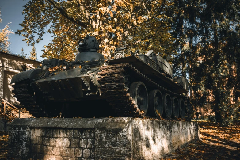 a rusted out tank stands out against a tree